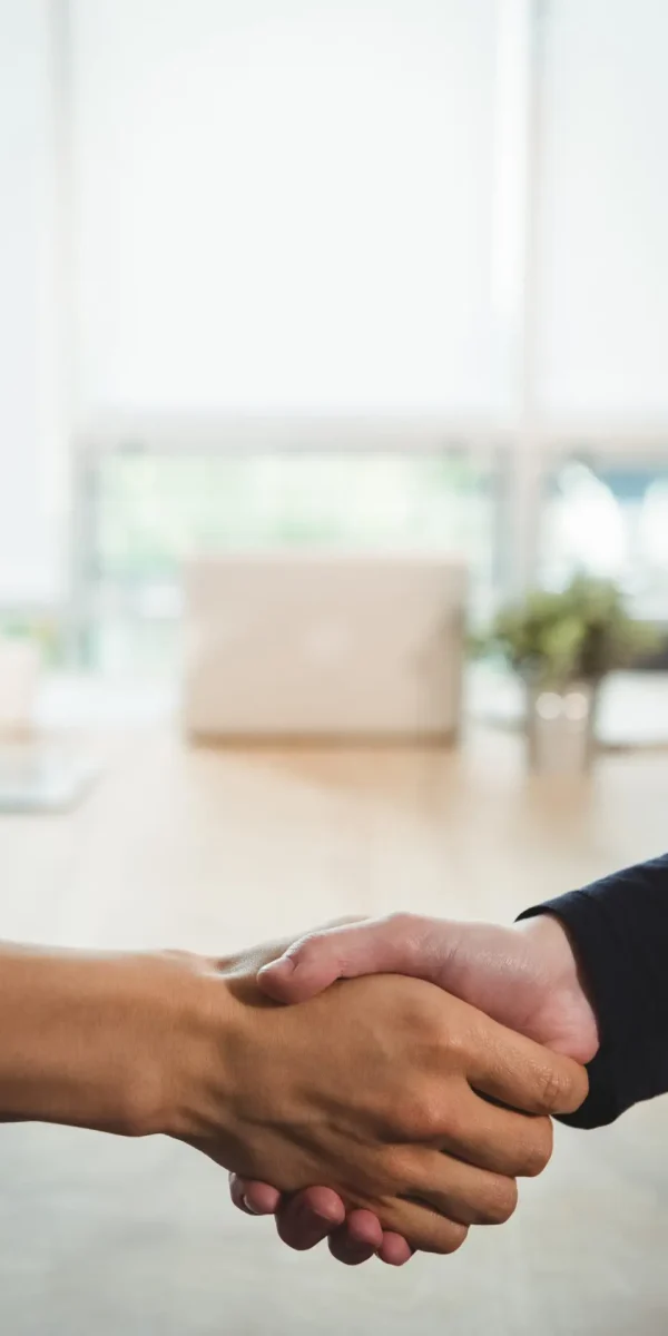 Business executives shaking hands with each other in office